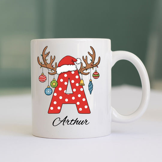 Personalised Christmas initial mug with red polka-dot letter, Santa hat, reindeer antlers and name